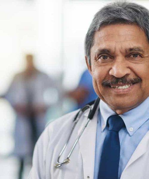 doctor-medical-professional-healthcare-worker-with-smiling-happy-friendly-face-expression-hospital-colleagues-background-closeup-portrait-headshot-mature-clinic-specialistcp.jpg